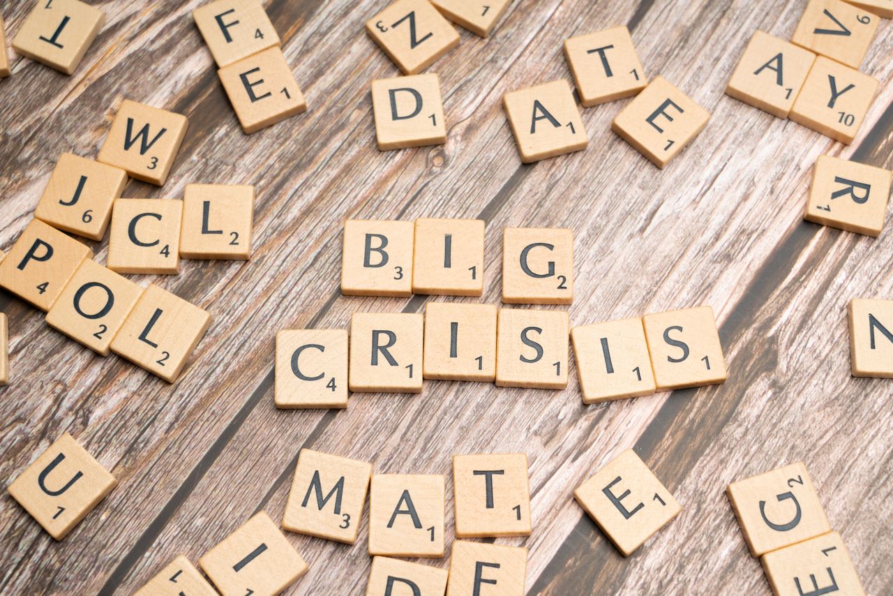 Wooden tiles forming the words Big Crisis on a wooden background.